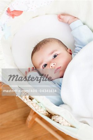 Portrait of a bright baby lying in his cradle at home