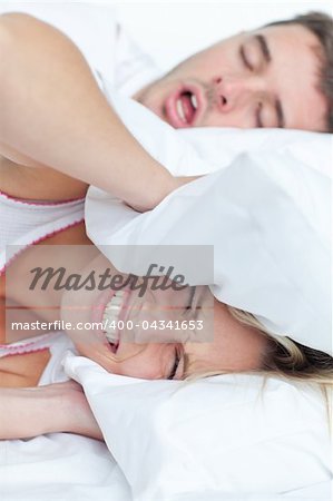 Young couple in bed woman trying to sleep while a man is snoring