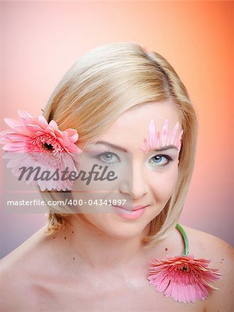 Close-up of woman green eye. Pink flower on background.