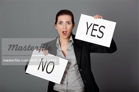Business young woman trying to make a decision between Yes or No choice, over a gray background