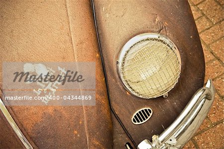 rusty old car with a sign of trust painted on the hood