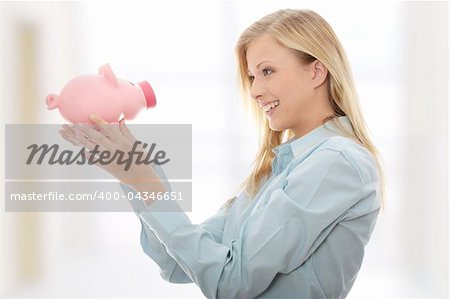 Businesswoman holding piggy bank.