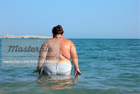overweight woman bath in sea - rear view