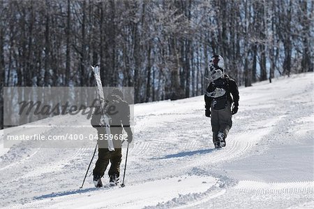 skiers  hike on mountain peak