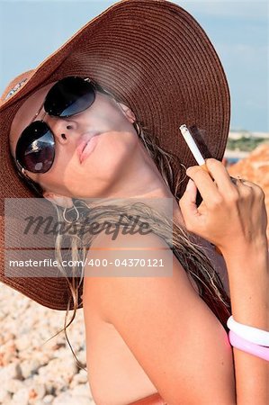 attractive woman in a hat smoking a cigarette