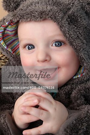 Four month old baby boy wearing a fully bear suit