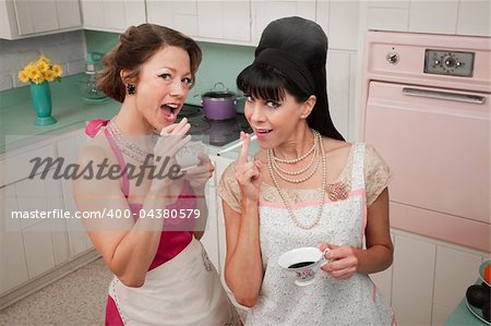 Two women smoke cigarettes while having coffee in a retro kitchen scene