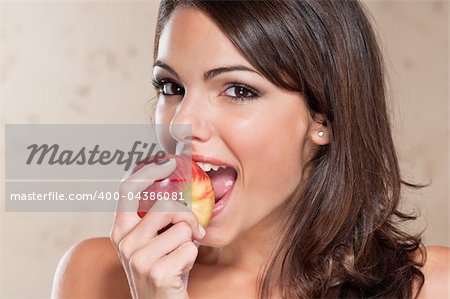 Portrait of pretty young woman eating an apple