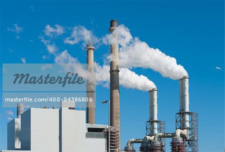 power plant with smoking chimneys in rotterdam, netherlands