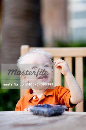 happy toddler eating blueberries