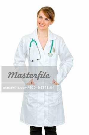 Smiling medical doctor woman with hands in pockets of robe looking at copy space isolated on white