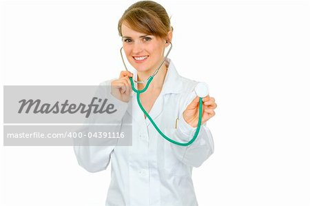 Smiling medical female doctor holding up stethoscope isolated on white