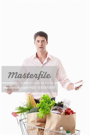 Surprised man with a cart with food on a white background