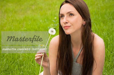 Girl with dandelion on green field