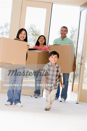 Family with boxes moving into new home smiling