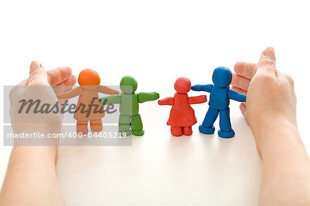 Hands protecting colorful clay people family - on white