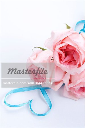 A bouquet of roses with ribbon in heart shape