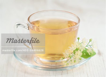 Cup of tea and linden flowers on wooden background