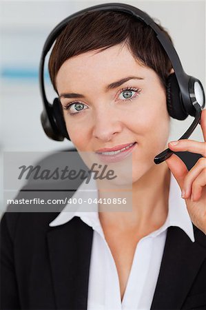 Portrait of a cute secretary calling with a headset in her office