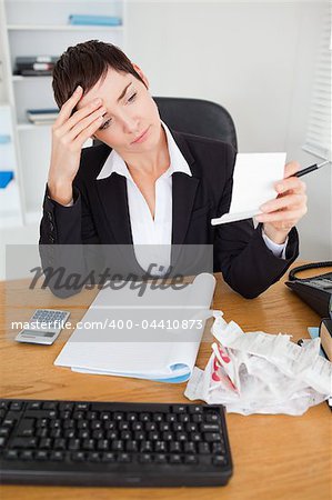 Portrait of a serious accountant checking receipts in her office