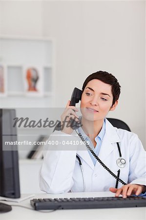 Portrait of a female doctor making a phone call in her office