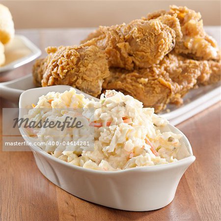 coleslaw with fried chicken in background.