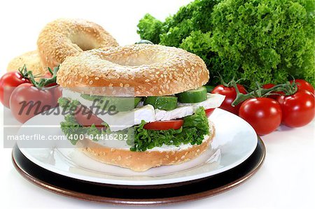 Bagel topped with a camembert cheese, cucumber and tomato