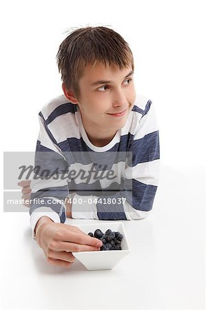 Boy with a bowl of berries.  He is looking sideways, suitable for message.  White background.