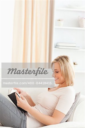 Woman reading a book in her living room