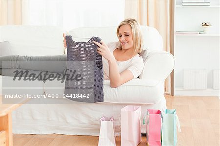 Woman looking at the clothes she bought in her living room