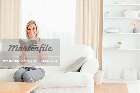 Blond-haired woman with a book in her living room