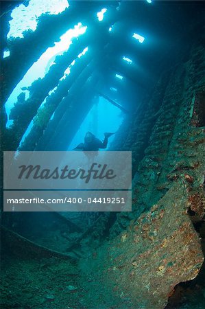 Scuba diver exploring the interior of a large shipwreck