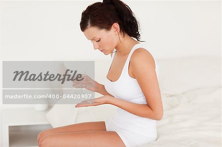 Sick woman taking pills in the bedroom