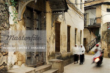 Motion photo of children on their way to school in Stone Town alleys, Zanzibar Island, World Heritage Site