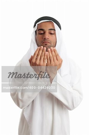 An arab middle eastern man dressed in traditional rob and headdress with open hands praying.