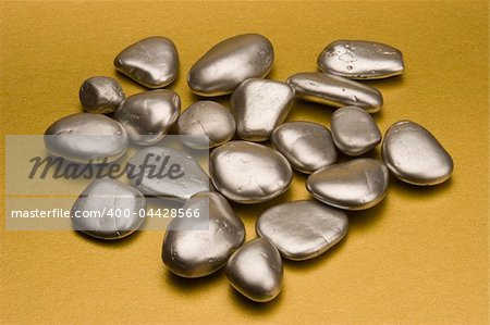 Silver pebbles against a gold background