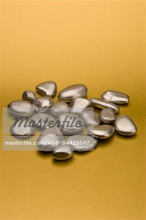 Silver pebbles against a gold background