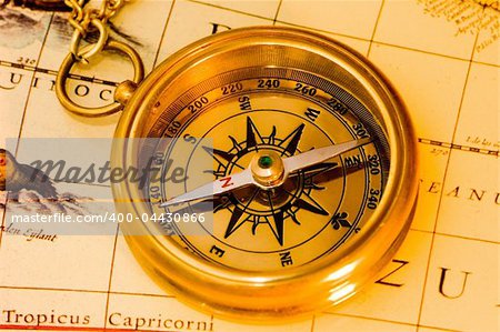 Old style brass compass on antique  map