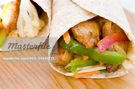 Caribbean style wrap stuffed with jerk chicken, sweet pepper and cabbage. Shallow DOF.