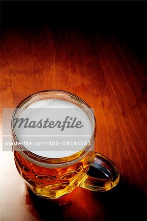 Full glass of beer on dark table