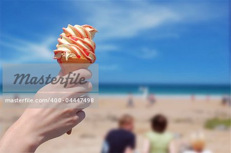 A person holding an ice cream on a beach