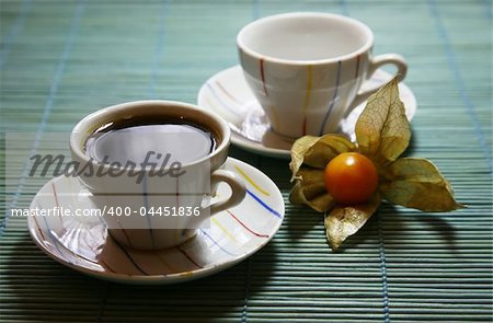 Two cups on a green wooden napkin