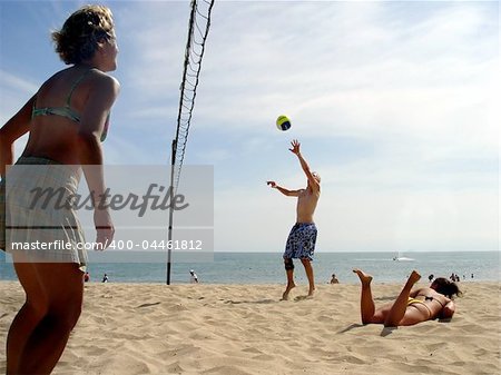 Men and a girl playing volleyball