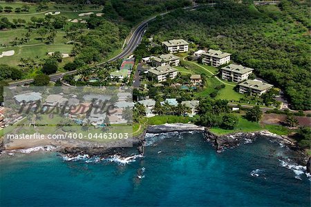 Aerial of houses clustered by Maui, Hawaii coast.