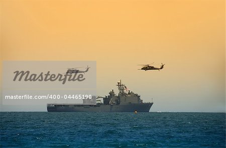 Navy battleship cruising to mission with helicopter escorts