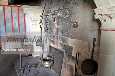 Antique kitchen in castle fireplace with old pots and pans