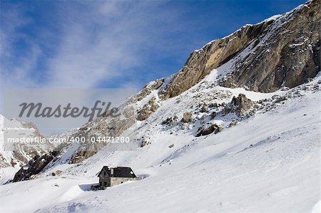 Beautiful little house high in the mountain, covered with snow.