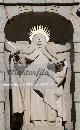 A woman statue with a bible and a feather