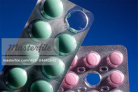Pink and green tablets on a dark blue background