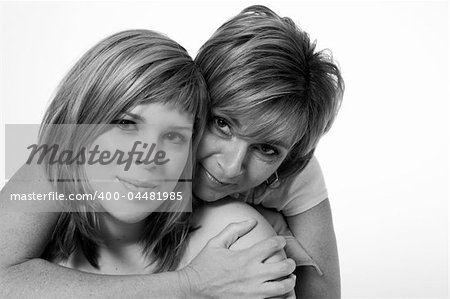 A portrait taken from mother and daughter taken on a white background holding on to each other